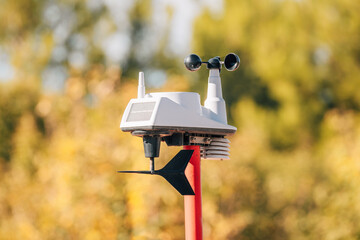 Weather station collecting meteorological data with anemometer, wind vane, and solar panel for climate research and forecasting