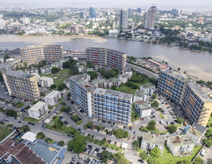 Aerial view of buildings with geometric patterns stand amidst a blend of natural waterways and urban architecture, Lagos, Nigeria.