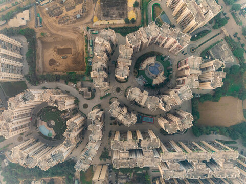 Aerial view of geometric buildings casting shadows on the ground, showcasing the intricate urban design, Gurugram, Haryana, India.