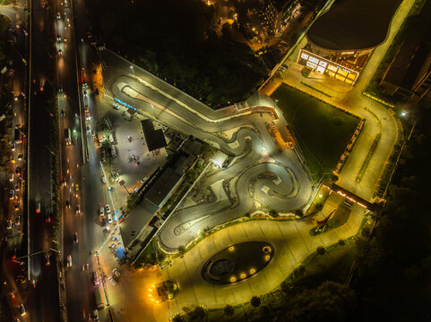 Aerial view of the illuminated go-kart track and surrounding buildings, a vibrant spectacle of light and shadow, Gurugram, Haryana, India.