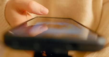 Finger sliding across smartphone screen, revealing digital content with soft illumination highlighting intricate scrolling motion and personal interaction