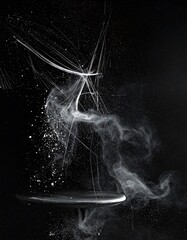 White powder explodes from disc against a dark background.