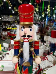 Nutcracker soldier drummer standing as a traditional christmas holiday decoration with red hat, blue uniform, white beard and gold trim, painted wooden festive figure