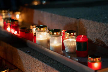 Dozens of lit lanterns illuminating Krastmala steps during Lāčplēša Day, showing structured candle rows, reflective metal lids and diverse glass containers