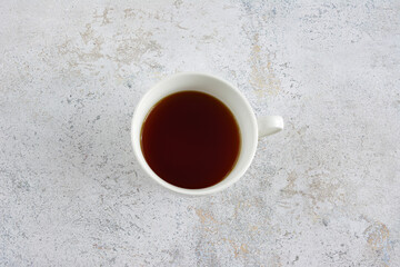 Overhead View of a White Cup with Dark Beverage on Textured Surface
