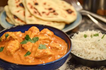 Rich and creamy butter chicken served with naan bread and a side of basmati rice