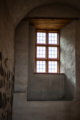 Obraz premium Old castle interior with antique furniture, stone walls, and warm light creating a medieval atmosphere full of history and mystery.