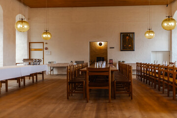 Majestic medieval castle banquet hall with long wooden tables, chandeliers, and stone walls illuminated by warm candlelight, evoking the atmosphere of royal feasts.