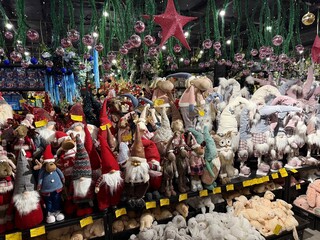 Fototapeta premium Festive store display featuring a large collection of christmas gnomes, stuffed animals, and decorative ornaments creating a cheerful holiday shopping atmosphere