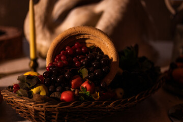 Old castle kitchen with a staged medieval food display on a wooden table. Historical atmosphere recreated with antique props, pottery, and fake food for heritage exhibition.