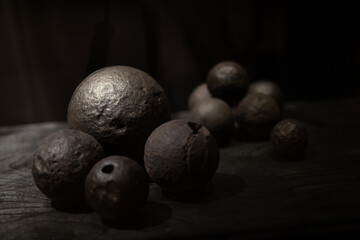 A collection of various antique objects inside a medieval castle: wooden chests, metal locks, ancient tools, sculptures, books, candles, and decorative elements. Warm light highlights textures, materi