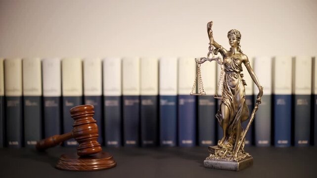 Themis goddes of justice and law with judge mallet gavel in motion and judge books unfocuseds in background , video footage