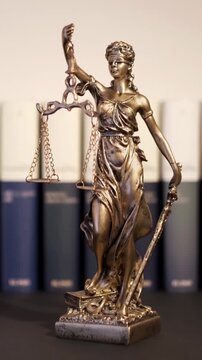 Themis goddes of justice and law with judge books unfocuseds in background , video footage