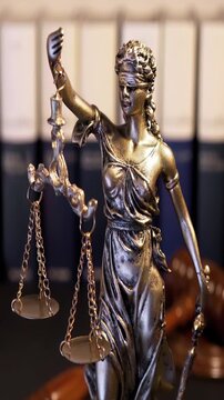 Themis goddes of justice and law with judge gavel mallet and books unfocuseds in background , video footage