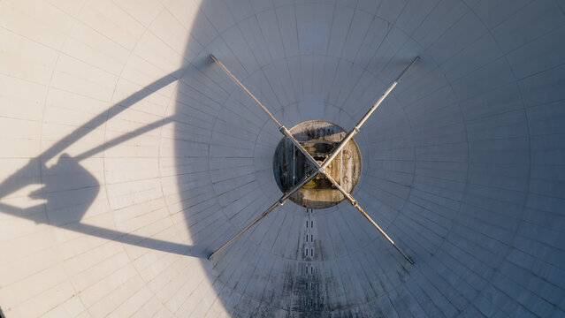 Aerial view of the gleaming white surface of the Radom Raisting, a symphony of geometric lines and shadows converging at its heart, Raisting, Bayern, Germany.