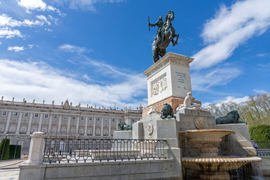 The bronze equestrian statue of King Philip IV (Felipe IV) on a high pedestal, set atop an ornate multi-tiered stone fountain, facing the Royal Palace in Madrid's Plaza de Oriente
