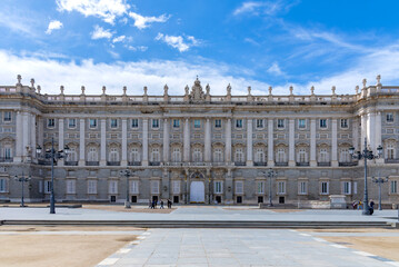 Majestic view of Madrid’s Royal Palace, captured from a medium distance, showcasing its grand façade, elegant symmetry, and regal architectural detail, subtle charm