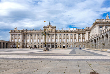 Majestic view of Madrid’s Royal Palace, captured from a medium distance, showcasing its grand façade, elegant symmetry, and regal architectural detail, subtle charm