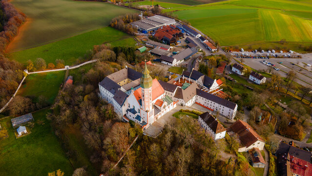 Aerial view of the Andechs Abbey with its ornate tower rising above the surrounding trees and fields, a beacon of history and faith, Andechs, Bayern, Germany.