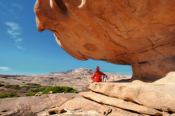 Solitude in a mystical land: a man and a faithful friend under the majestic stone vault of the Bektau Ata Nature Park in Kazakhstan, amidst untouched nature and vast expanses.