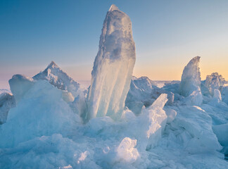 Majestic ice hummocks on a frozen lake at sunset or sunrise. The natural wonder of winter