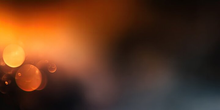 Soft focus of light orbs fading into dark gradient backdrop, warm to cool