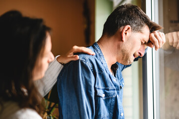 couple enjoying quiet time close to a window. The man crying and women consoling