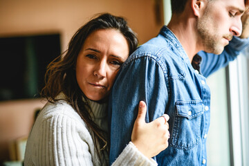 couple enjoying quiet time close to a window. The man crying and women consoling