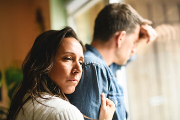 couple enjoying quiet time close to a window. The man crying and women consoling