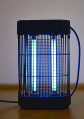 Electric insect killer lamp glowing in blue light