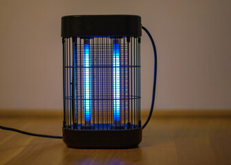 Electric insect killer lamp glowing in blue light