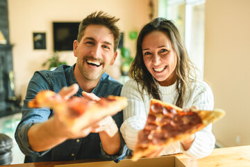 Loving couple shares tender moment in modern kitchen, enjoying pizza