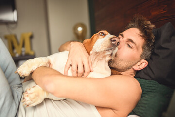 man and her Basset dog at home bed