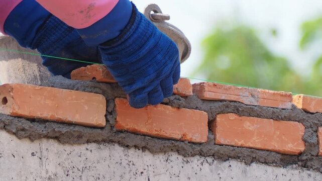 builder worker lays of brickwork with cement in construction site. building construction and industry concept