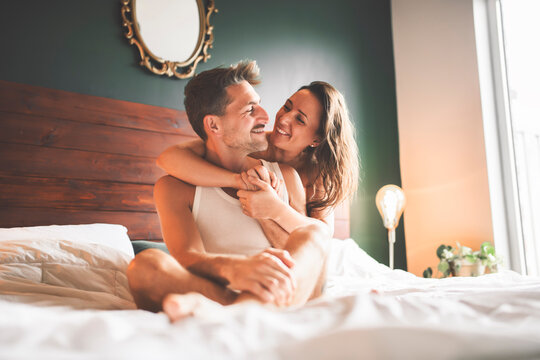 couple sharing tender on a cozy blanket in bed, enjoying love and affection