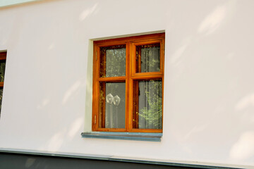A beautiful wooden window on the stone wall of a residential building
