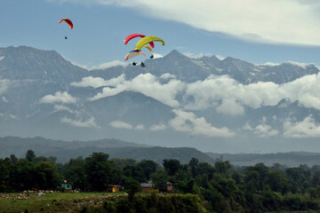 Paragliding over the clouds at Bir Billing Himachal Pradesh India. Clouds in the sky, Dhauladhar peaks view