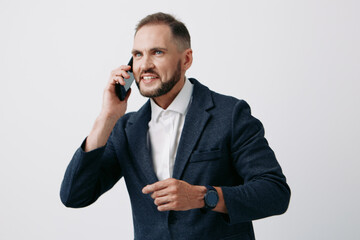 A professional man on a colored isolated background talks on a mobile phone with confident emotion, showing focus, motivation, and readiness in a business scene.
