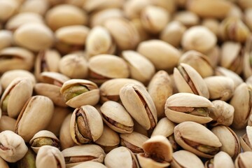 Tasty unpeeled pistachios as background, top view flat lay background