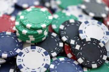 Close up of a group of casino chips on a green mat for poker or dice games indoors
