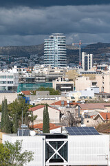 Modern building towering over residential houses in Limassol cityscape, Cyprus
