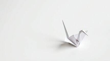 Minimalist white origami paper crane casting a delicate shadow on a clean white background