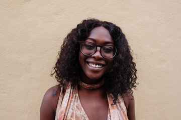 Black woman smiling, wearing glasses and showing joy