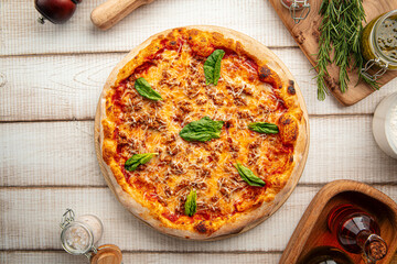 Freshly baked Italian pizza with tomato sauce, spinach leaves, and melted cheese on a wooden board