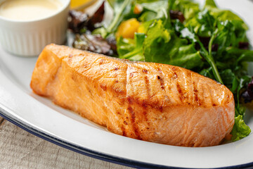 Tender grilled salmon fillet served with mixed greens and light dressing