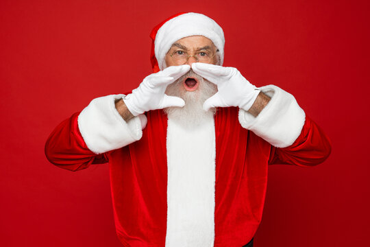 Winter noel sale discount reactions emotion concept. Stylish Santa white beard in costume headwear spectacles scream with open mouth staring eyes hear incredible news isolated on red background