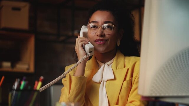 Smiling African American businesswoman in vintage outfit talking on phone - Powered by Adobe