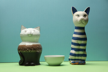 Still life with two cats patiently waiting for milk. Photo on blue background. Close-up with maximum depth of field.