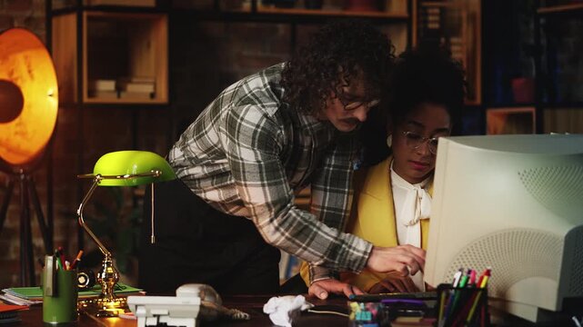 Male IT engineer showing female secretary how to use computer program, teamwork