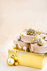 Christmas or New year round kraft gift boxes, gold holiday balls on a bokeh background of twinkling party lights of garland